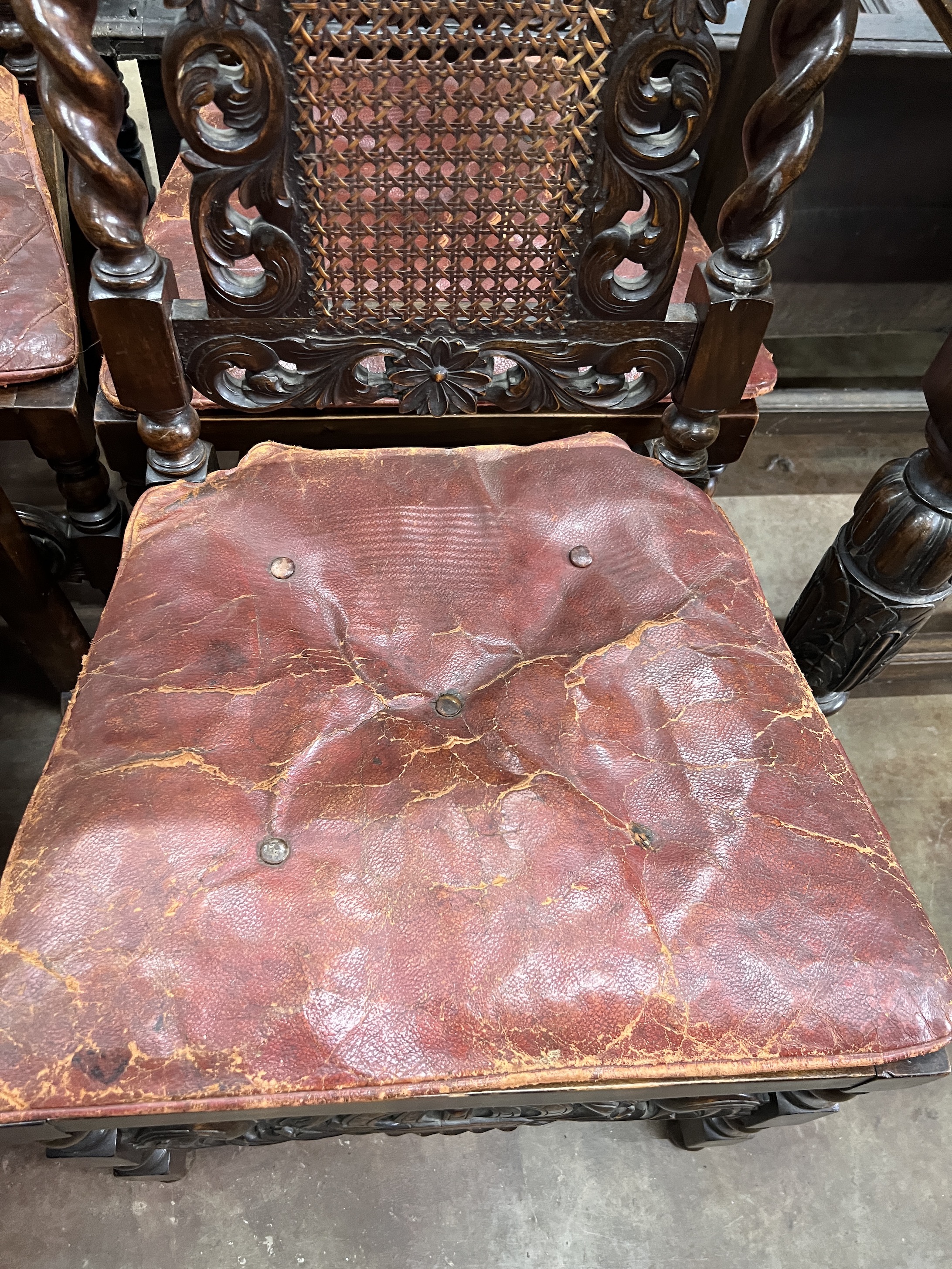 A set of six Jacobean revival carved caned beech dining chairs with leather squab seats